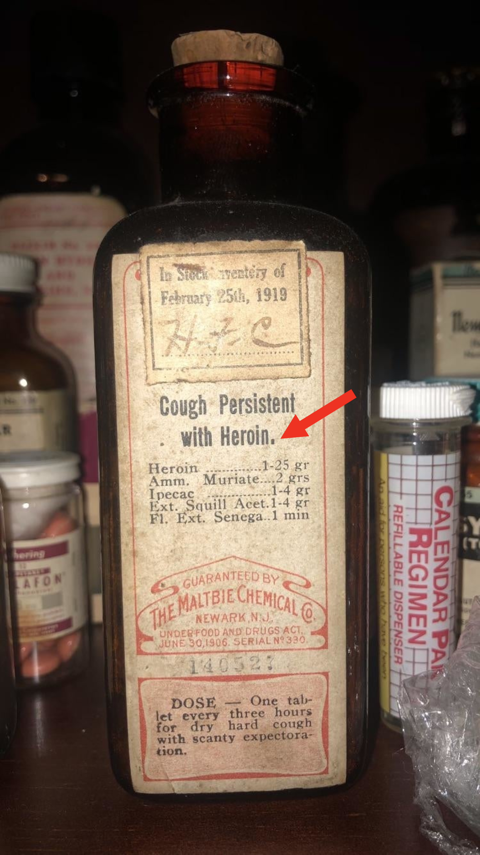 Arrow pointing to heroin on the label of a very old bottle: &quot;Cough Persistent With Heroin&quot;: Dose is &quot;one tablet every three hours for dry hard cough with scanty expectoration&quot;