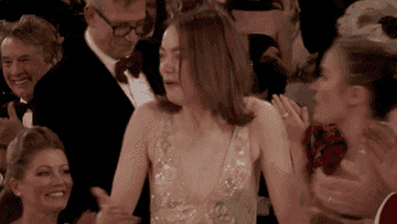 GIF of Emma Stone running up to the stage to accept her Golden Globe