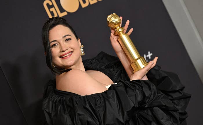 Closeup of Lily Gladstone holding her Golden Globe