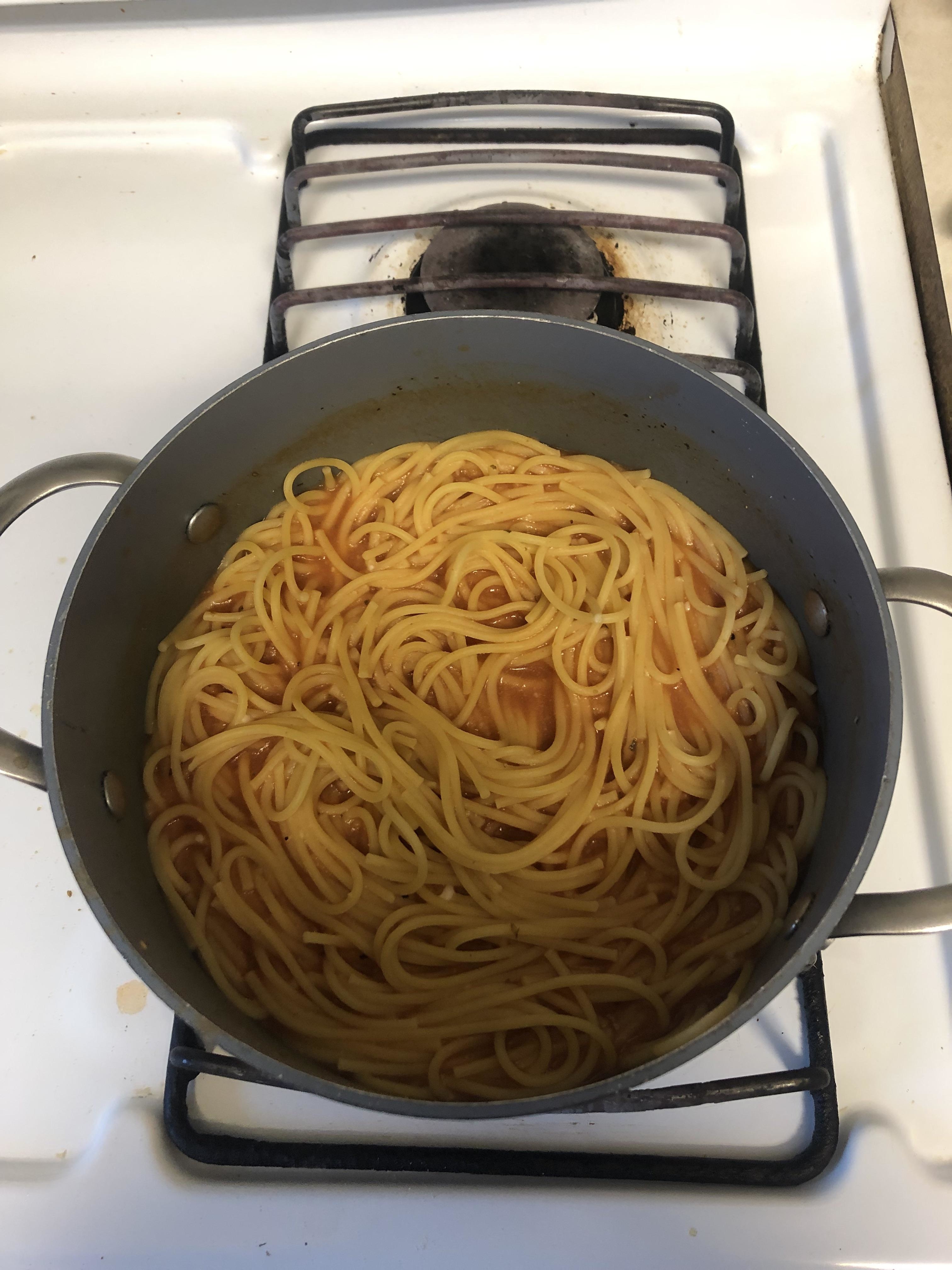 A pot of spaghetti with tomato sauce