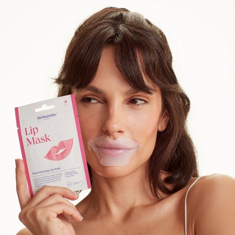 Model holding and wearing the lip mask