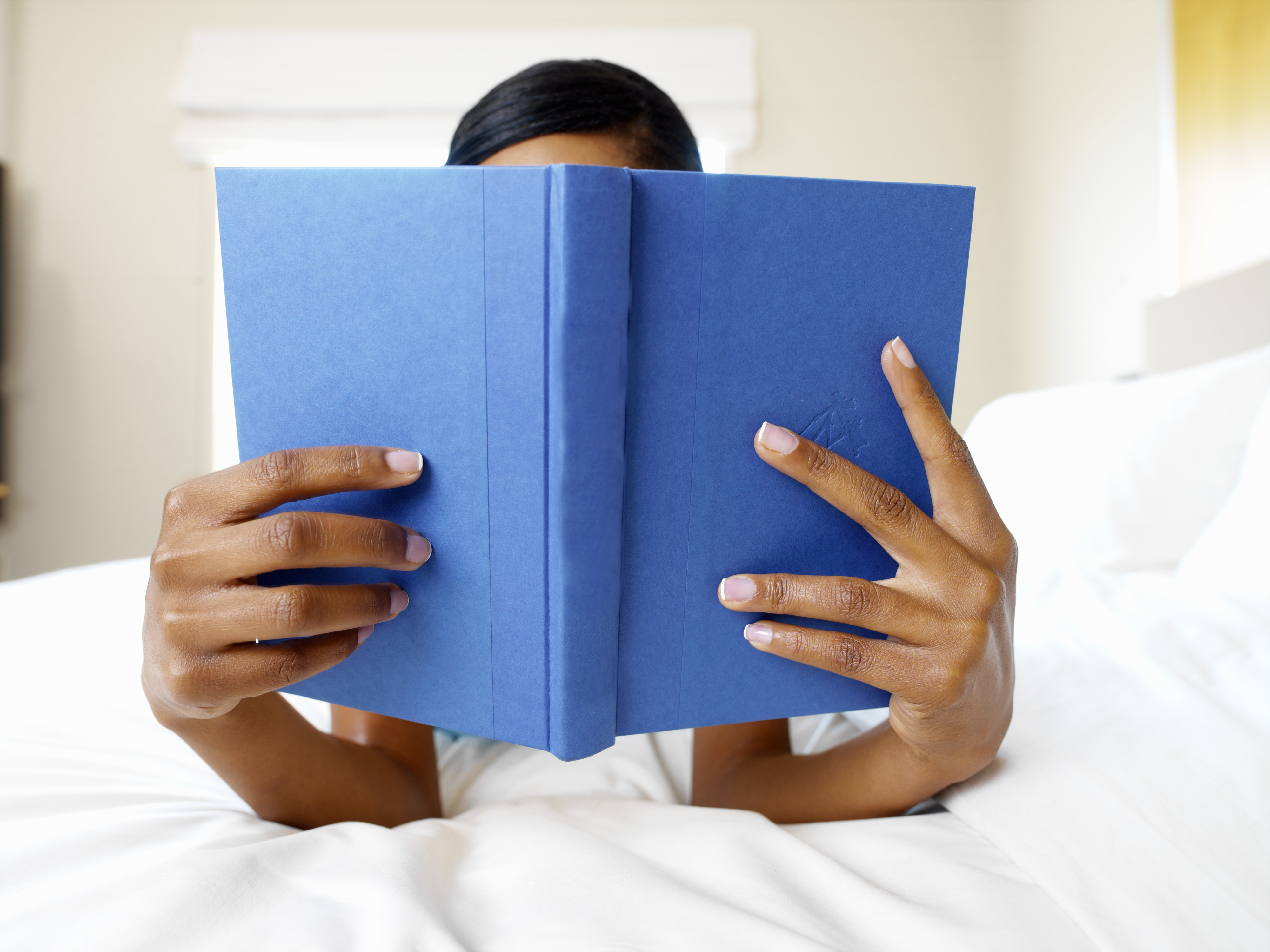 A woman reading a book in bed