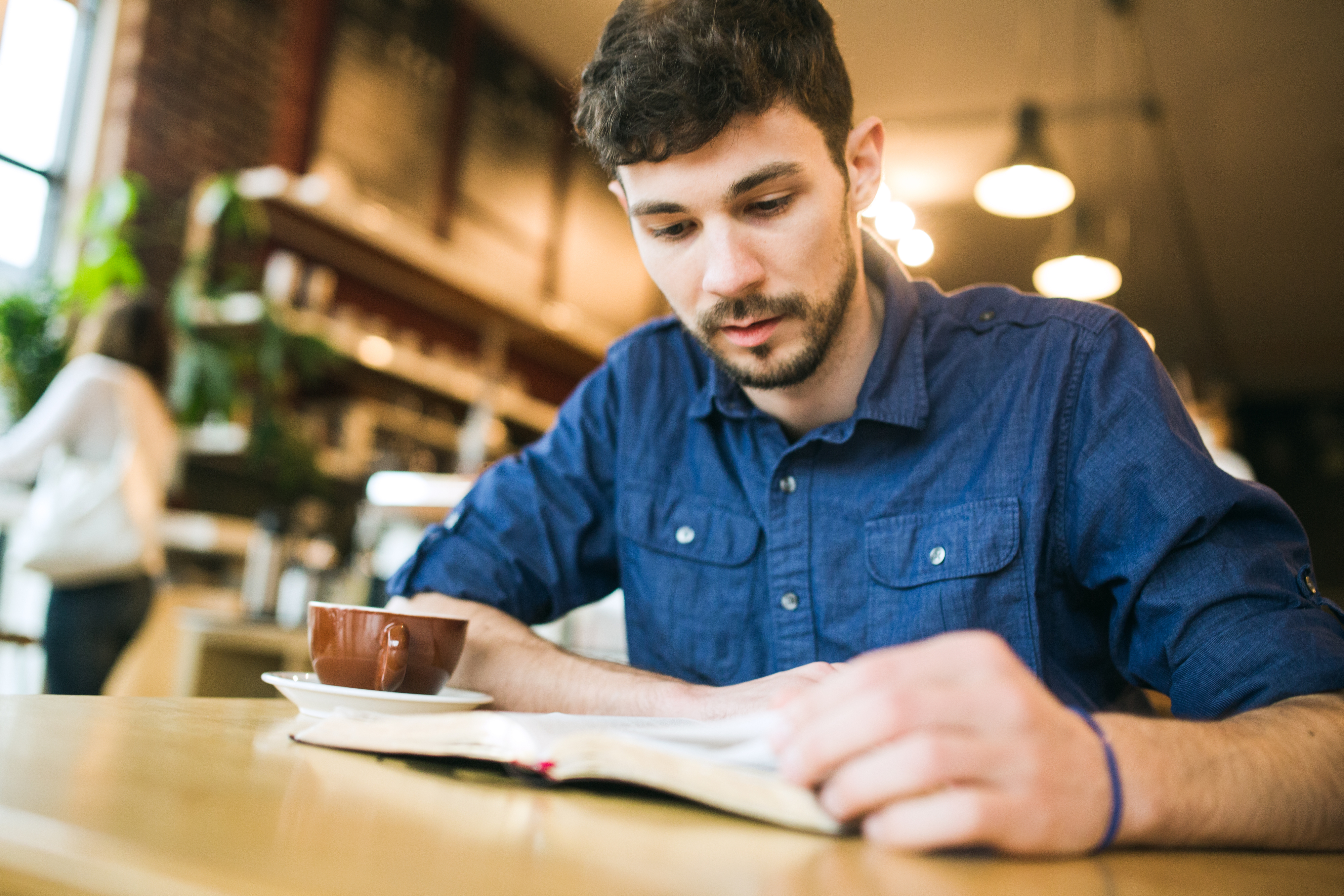 A young man reading in a café