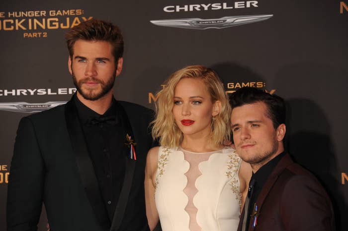 Liam Hemsworth poses on the red carpet alongside his co-stars Jennifer Lawrence and Josh Hutcherson