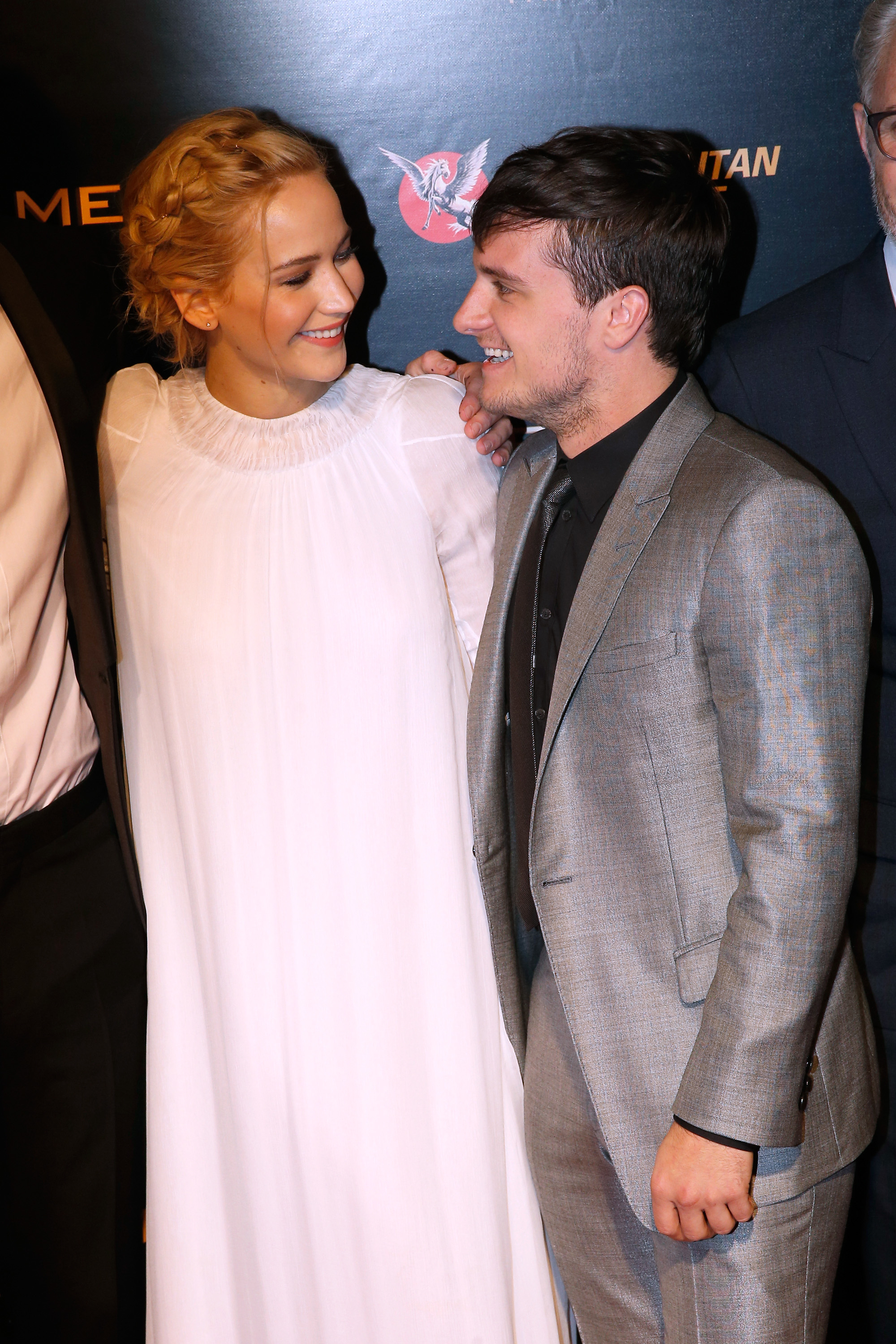 Jennifer and Josh smile as they look at each other during a press run