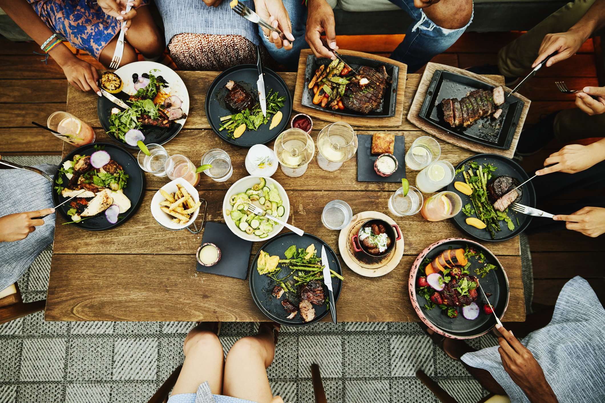 overhead view of people eating different dishes on a table