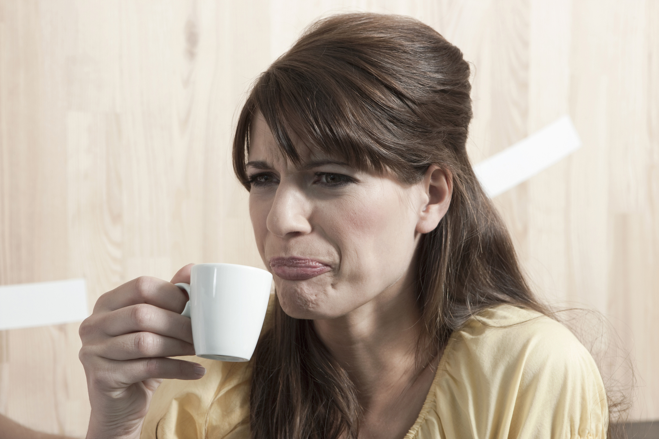 person making a disgusted face while drinking coffee