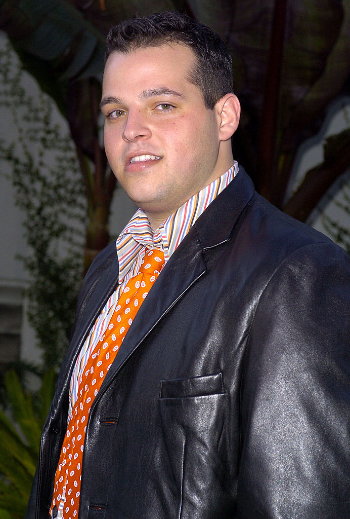 closeup of him in a leather jacket with a bright tie