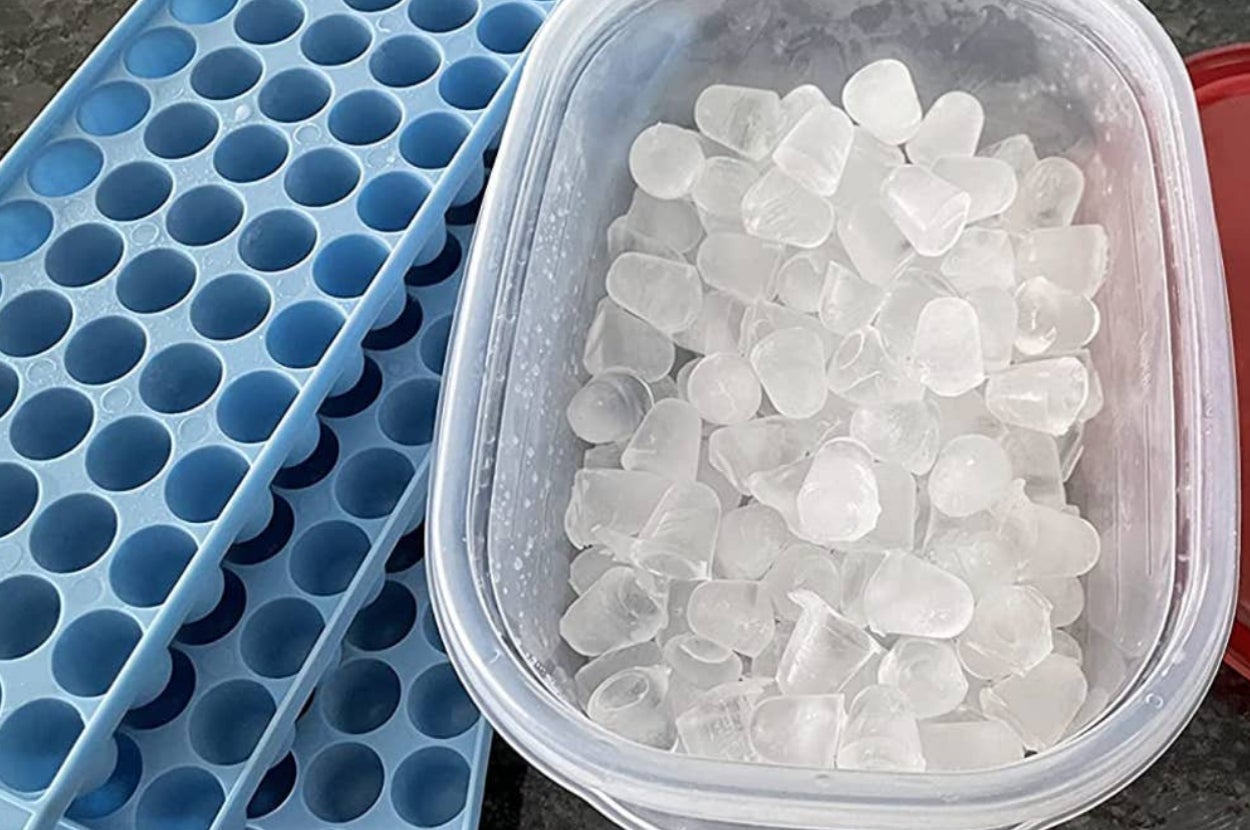 reviewer's ice cube trays stacked next to container full of ice