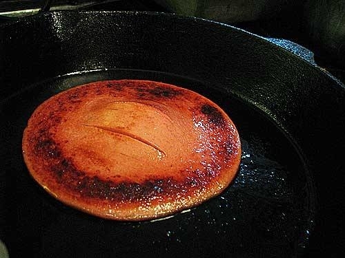 Bologna frying in a pan