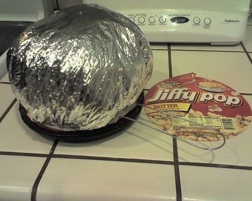 Stove-top Jiffy Pop popcorn with the aluminum foil top expanded