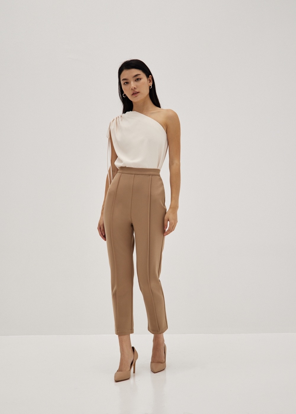 a model wearing the tan pants with a white top