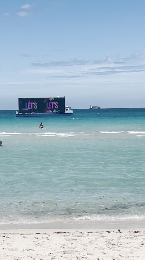 A boat with a holographic sign at the beach