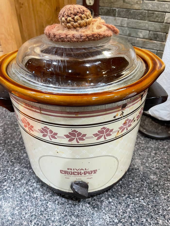 An old-school Rival Crock-Pot with a knit top