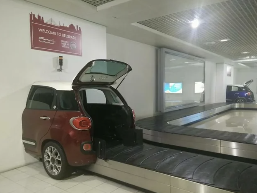 a baggage claim carousel with a car at the end