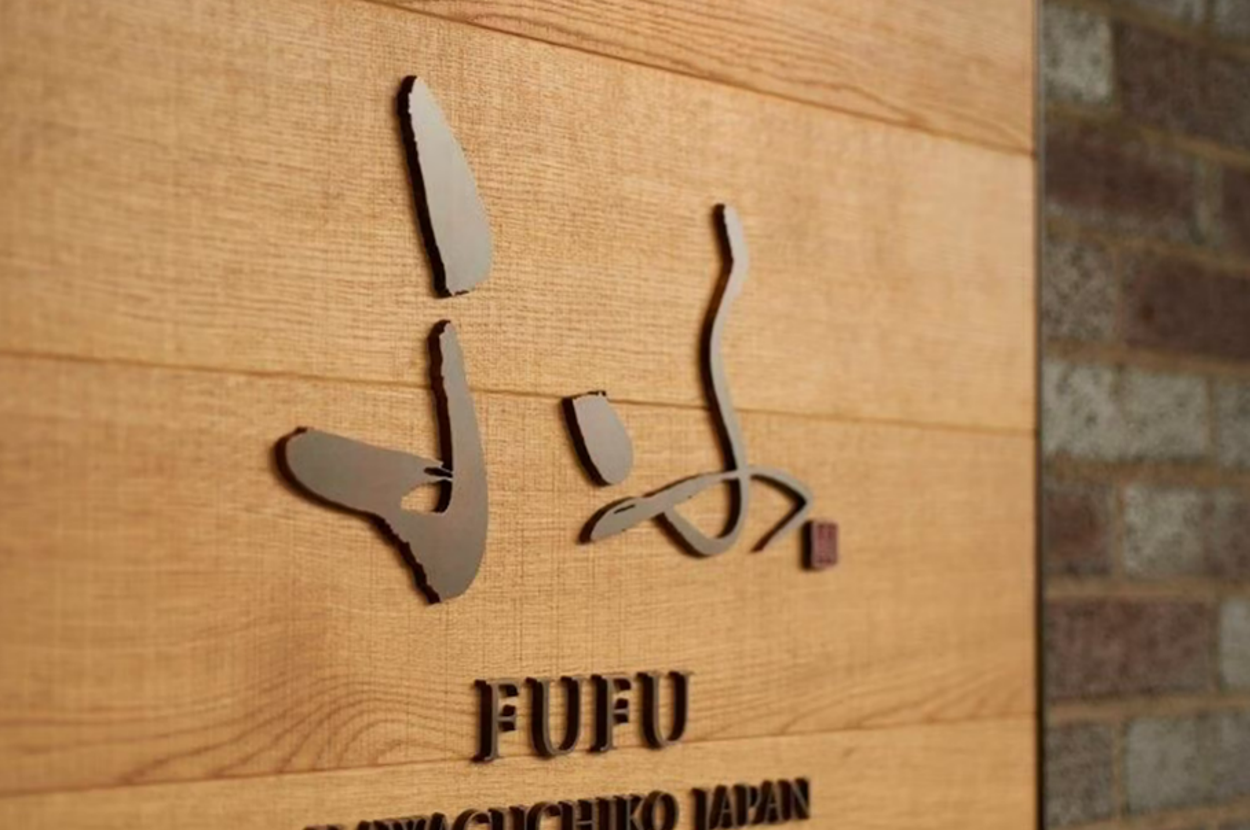 高級宿「ふふ」のロゴがあしらわれた木製の壁