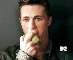 Man eats an apple with a straight face, almost ominously.