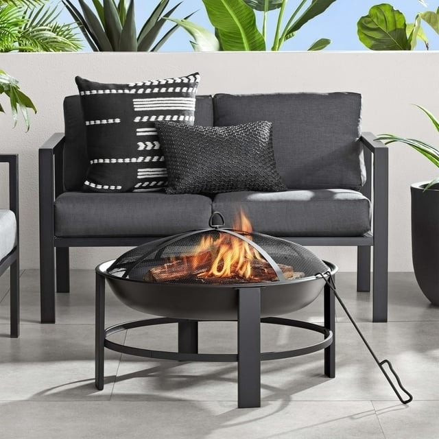 Outdoor patio setup with a sofa, patterned cushions, and a fire pit