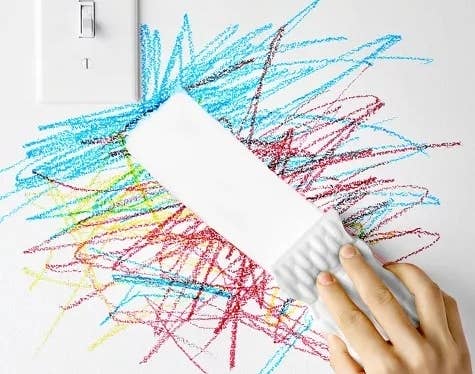 A magic eraser cleans crayon off of a wall