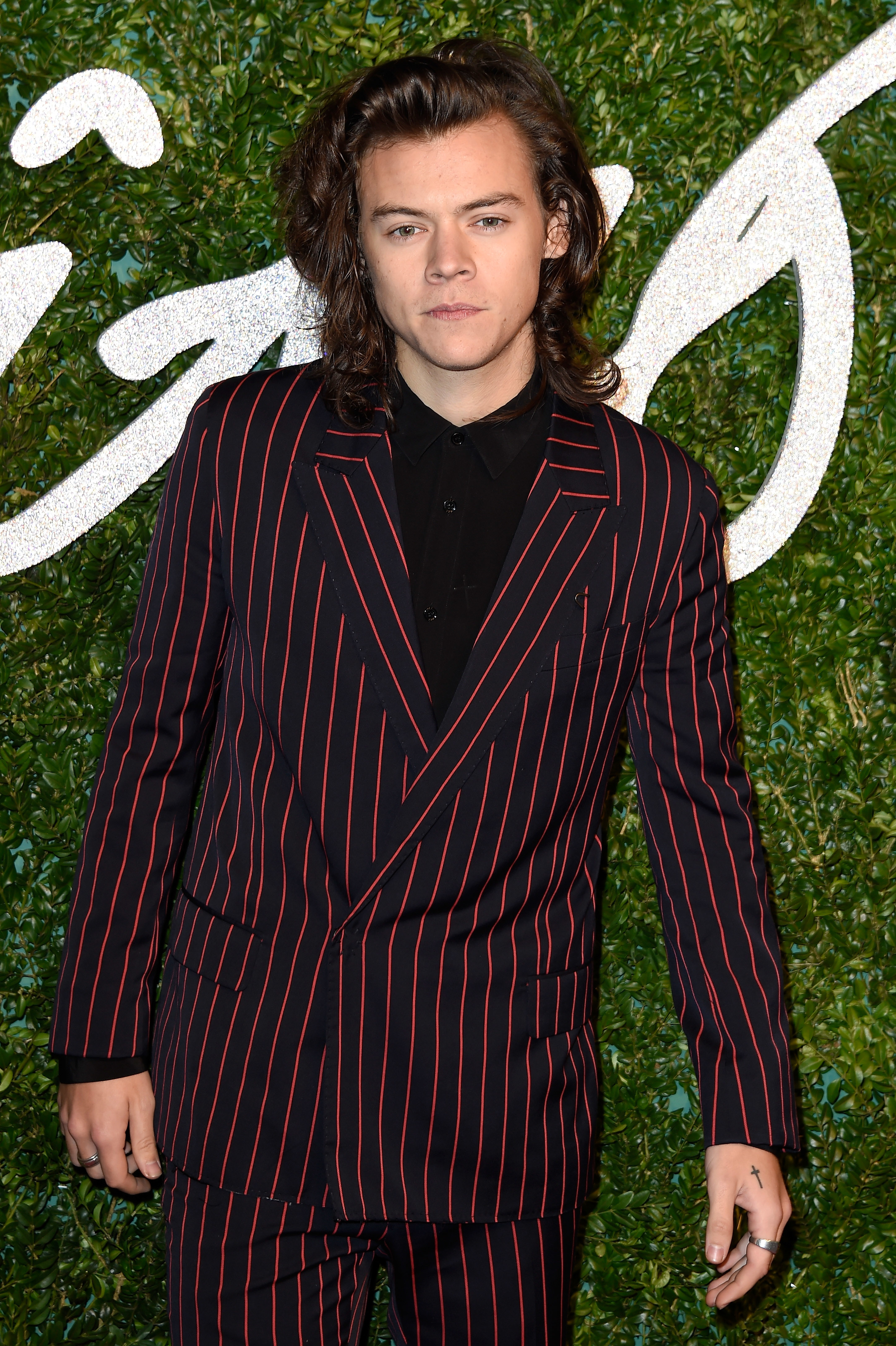 his hair is shoulder-length and he&#x27;s wearing a pinstripe suit