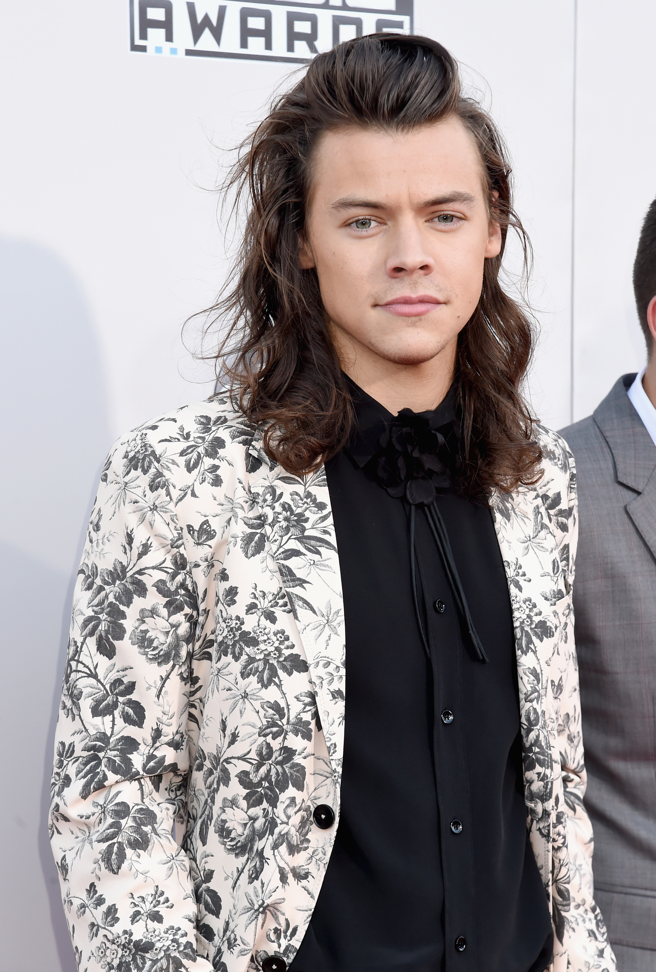he&#x27;s got long hair and he&#x27;s wearing a floral blazer