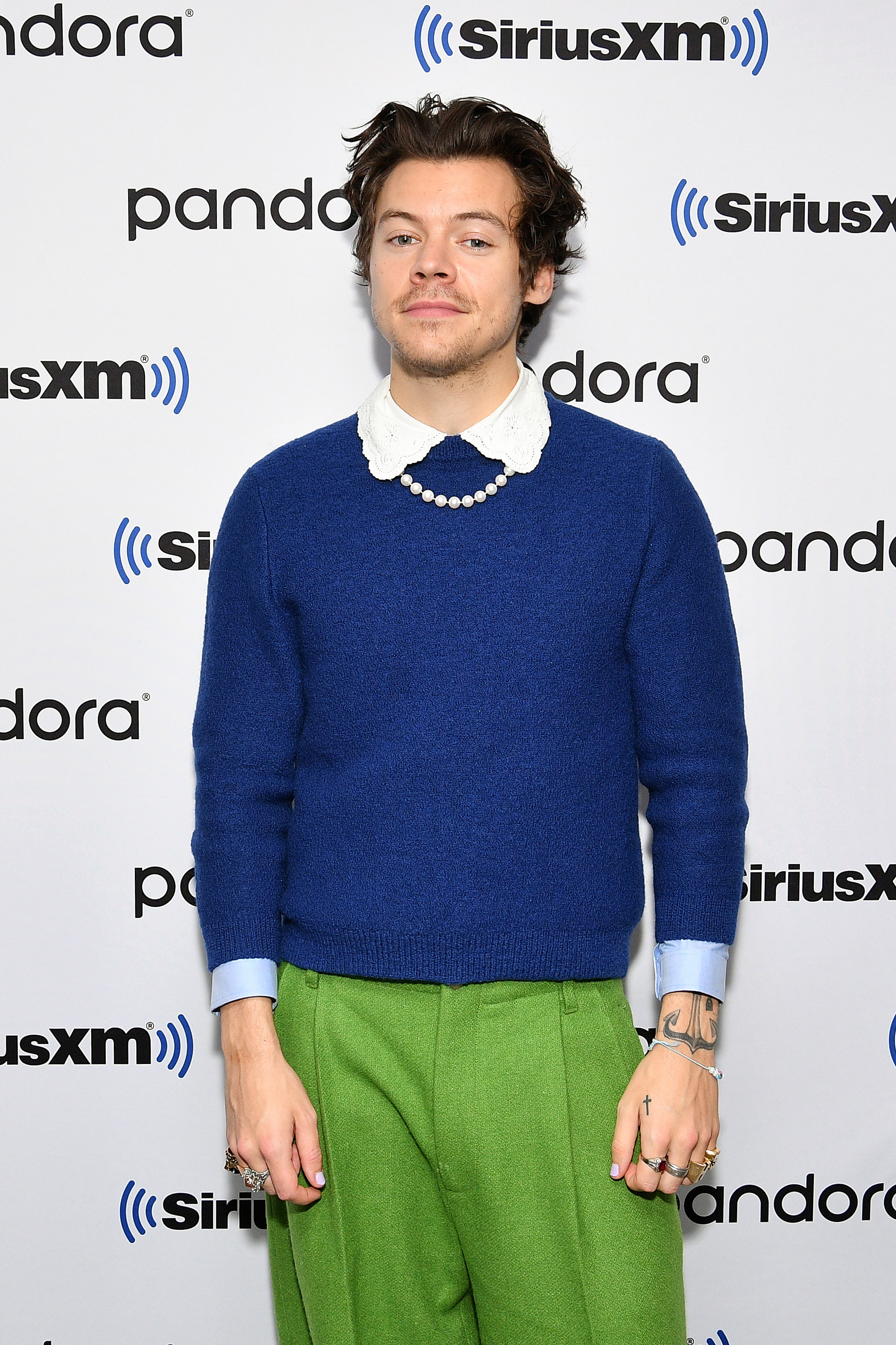 he&#x27;s wearing colorful pants and a sweater