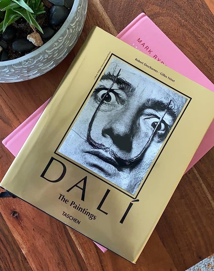 a reviewer photo of the gold colored book with Dali&#x27;s face on it