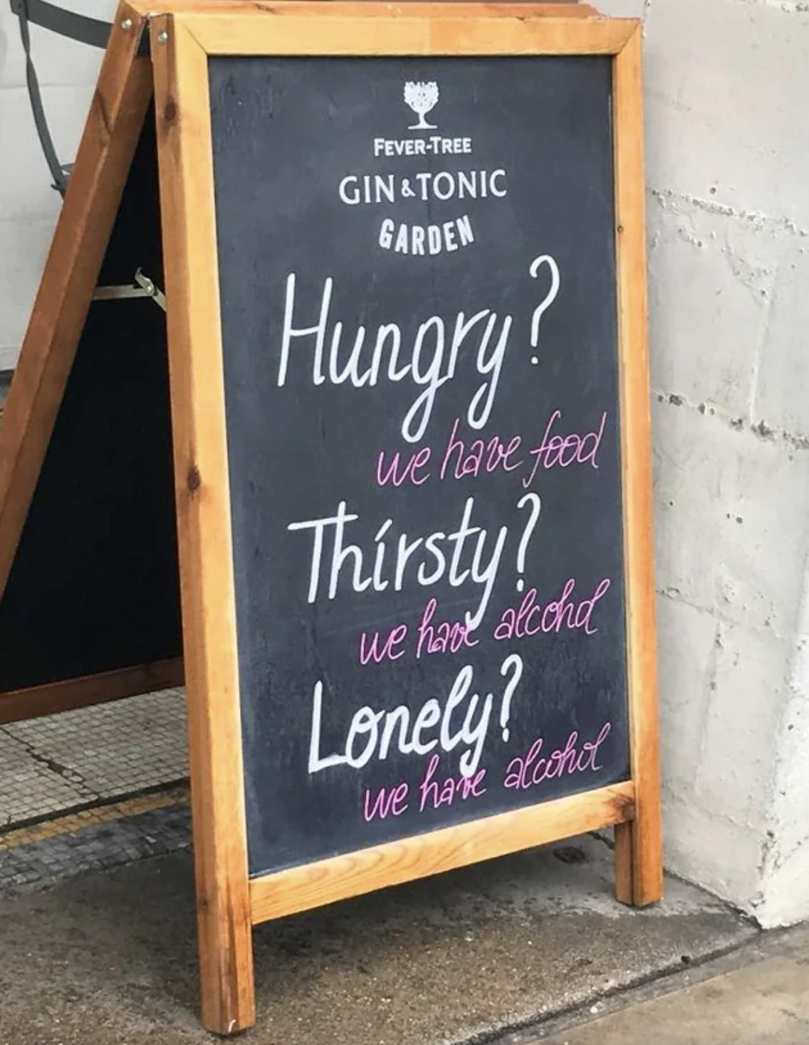 Handwritten on chalkboard outside store: &quot;Hungry? We have food / Thirsty? We have alcohol  / Lonely? we have alcohol&quot;