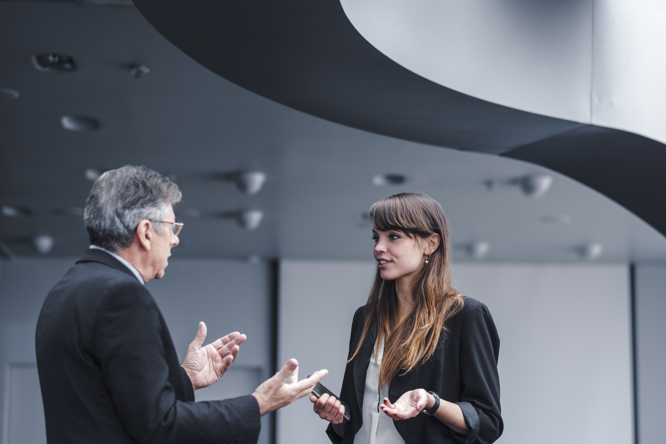 younger woman having a disagreement with her older boss