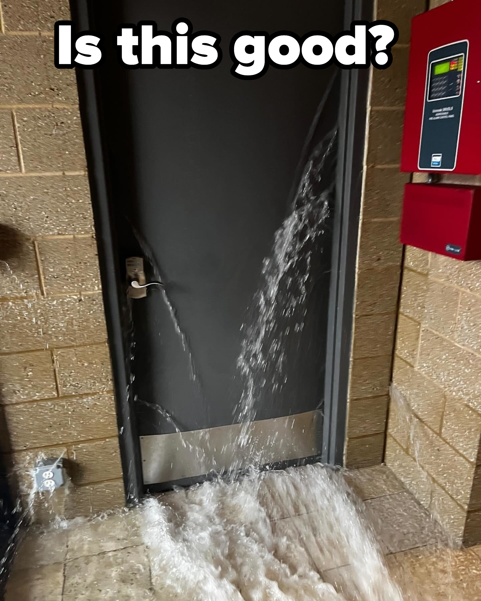 A shut door with water gushing out through the bottom and sides