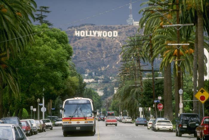 cars on the street with the hollywood sign in the distance