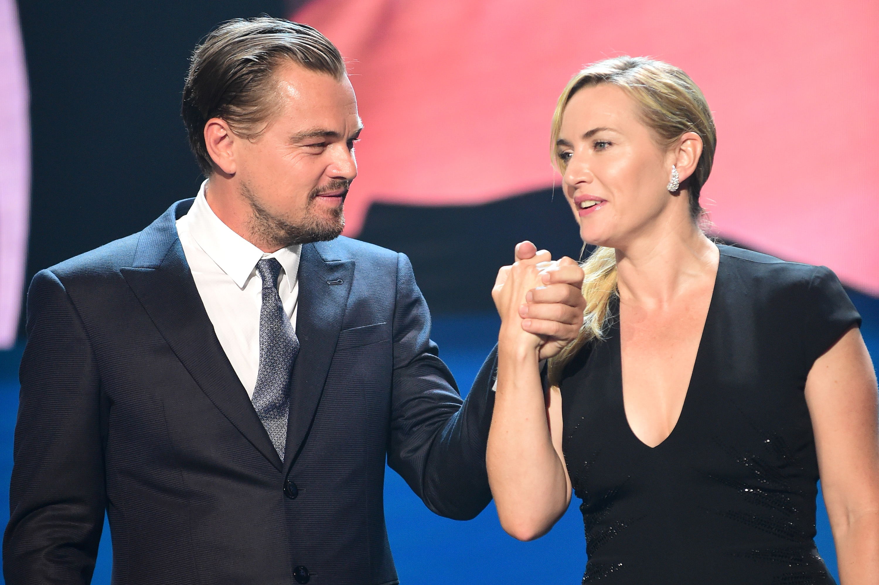 Close-up of Kate and Leo holding hands
