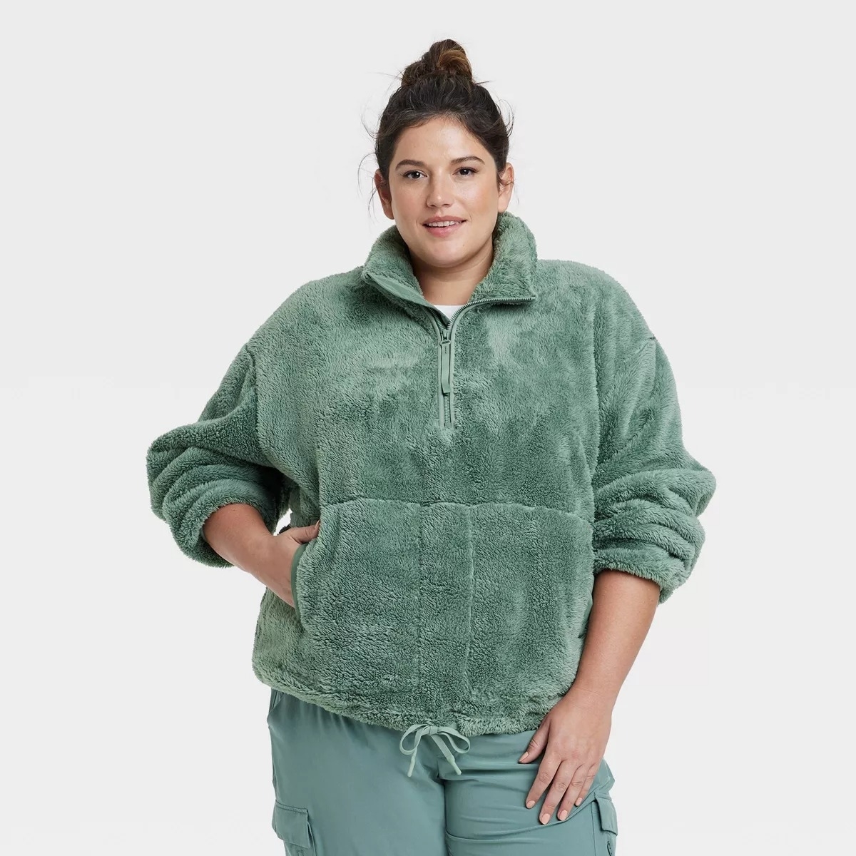 a person wearing a green half zip