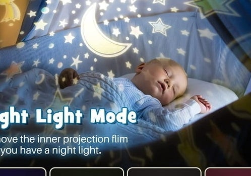 baby laying in crib with galaxy projection on the ceiling