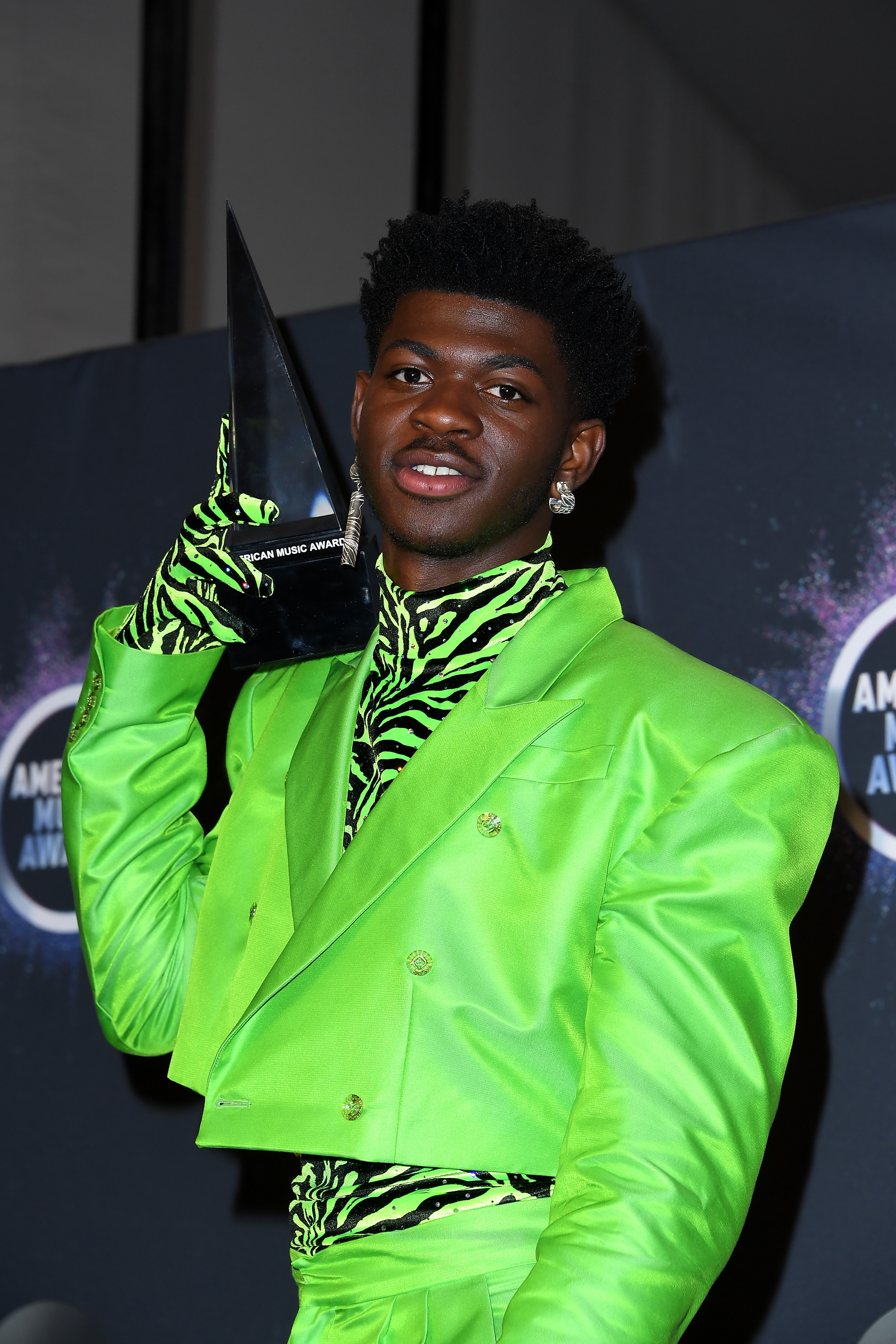Close-up of Lil Nas holding an award