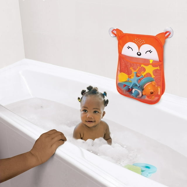 child taking a bath with bath toy bag hanging on the wall