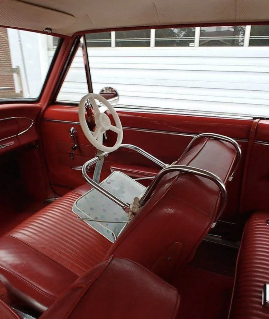 vintage car with front-facing carseat in front seat