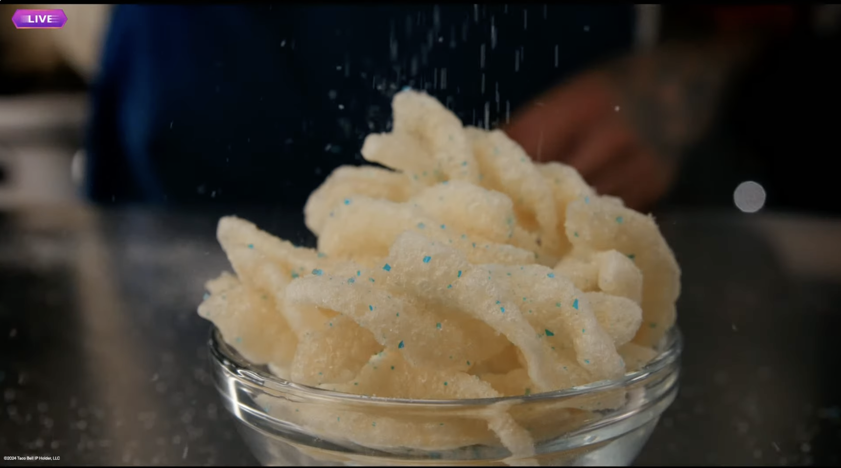 fried dough twists being sprinkled with bright blue baja blast powder