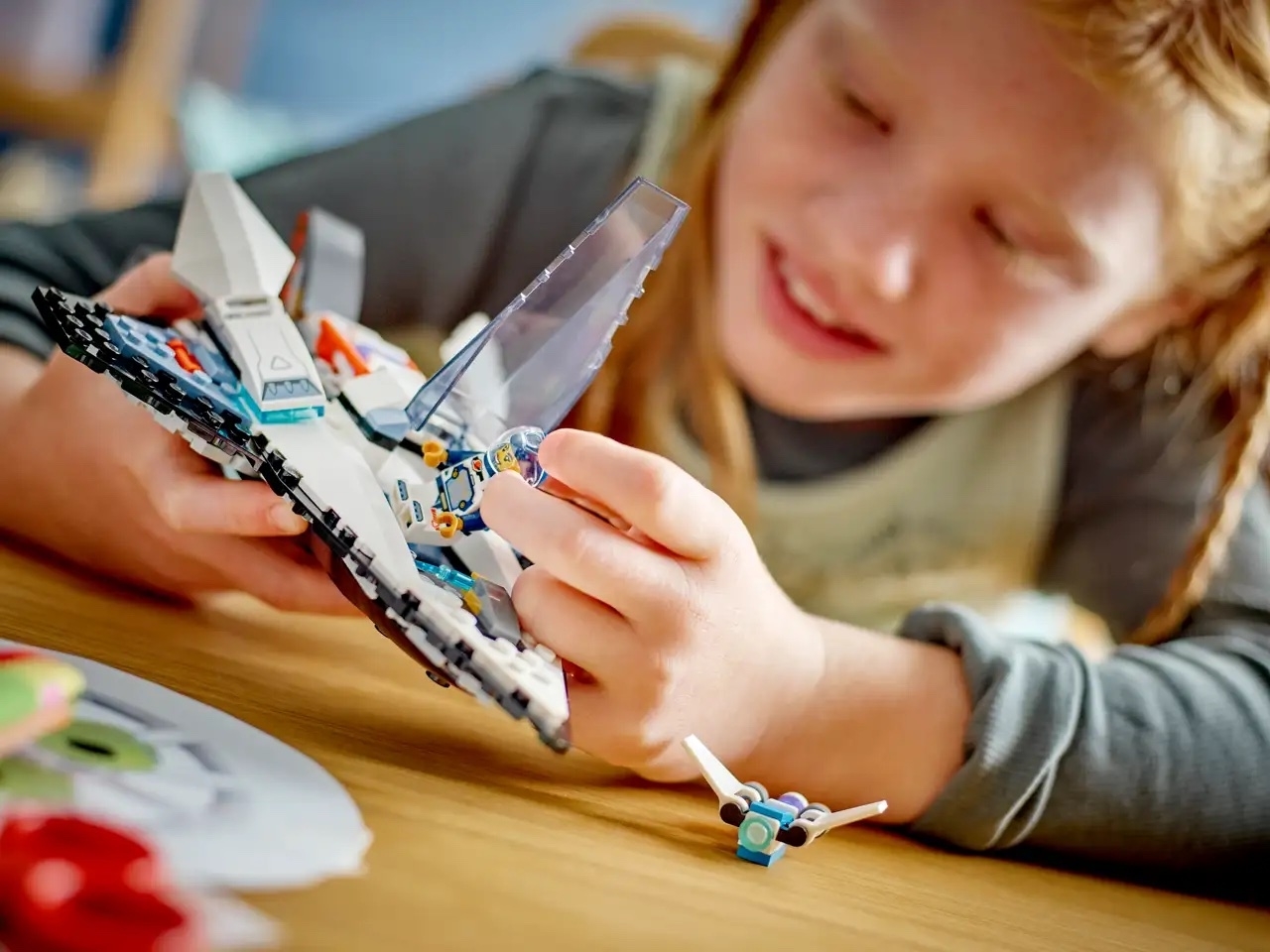 A young girl plays with a LEGO spaceship