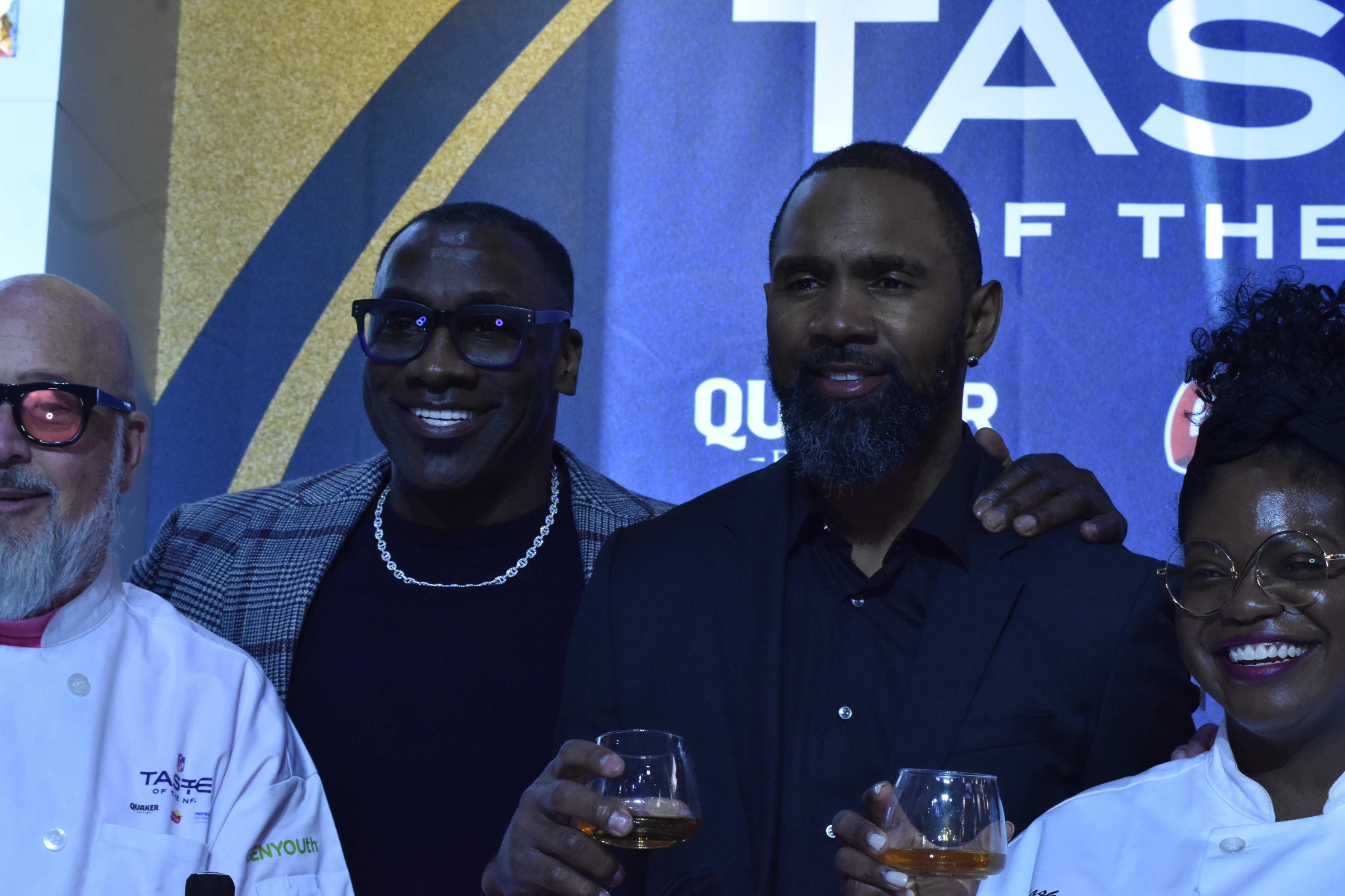 Celeb athletes and chefs holding drinks at a tasting event