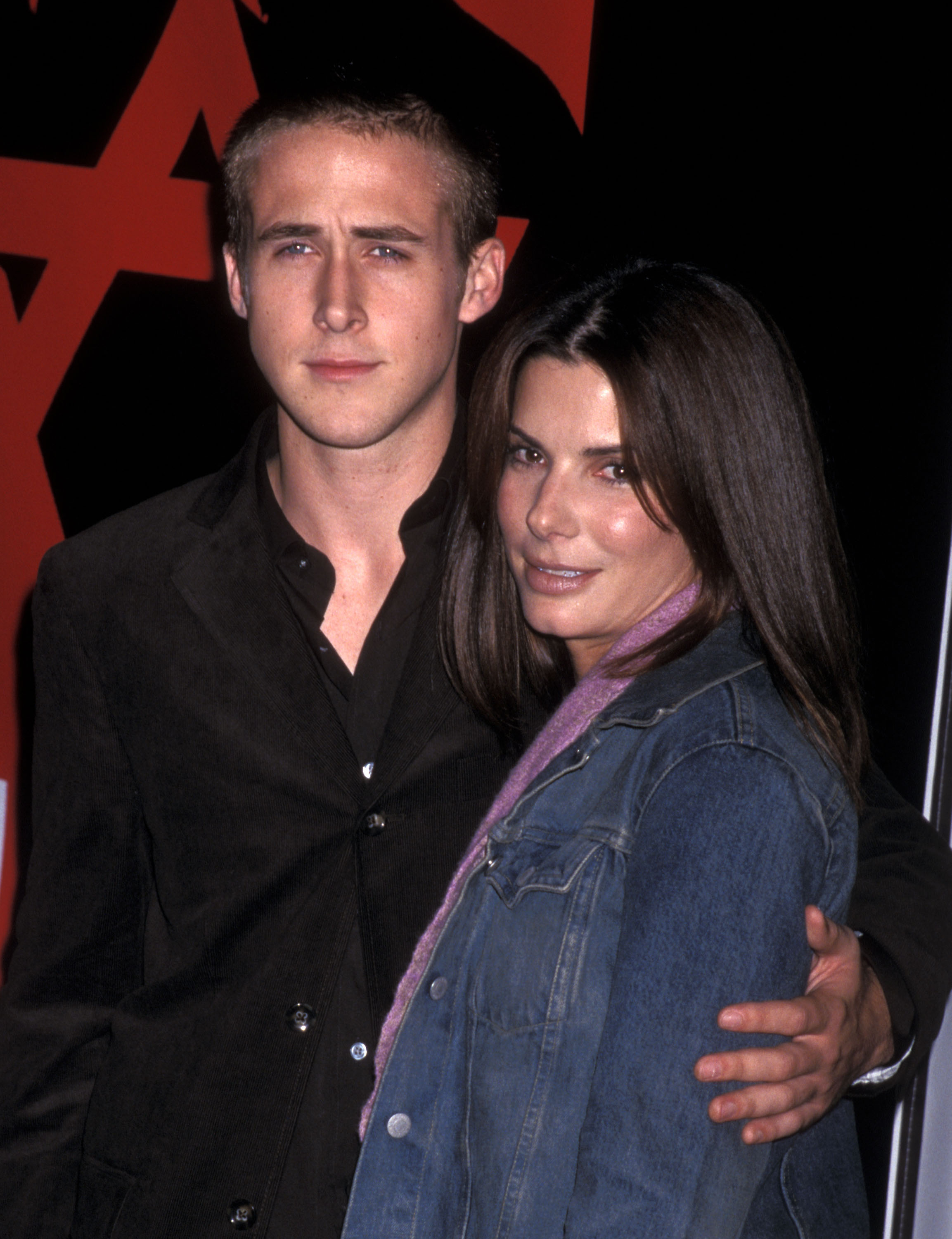 In a shirt with his arm around Sandra Bullock at a media event