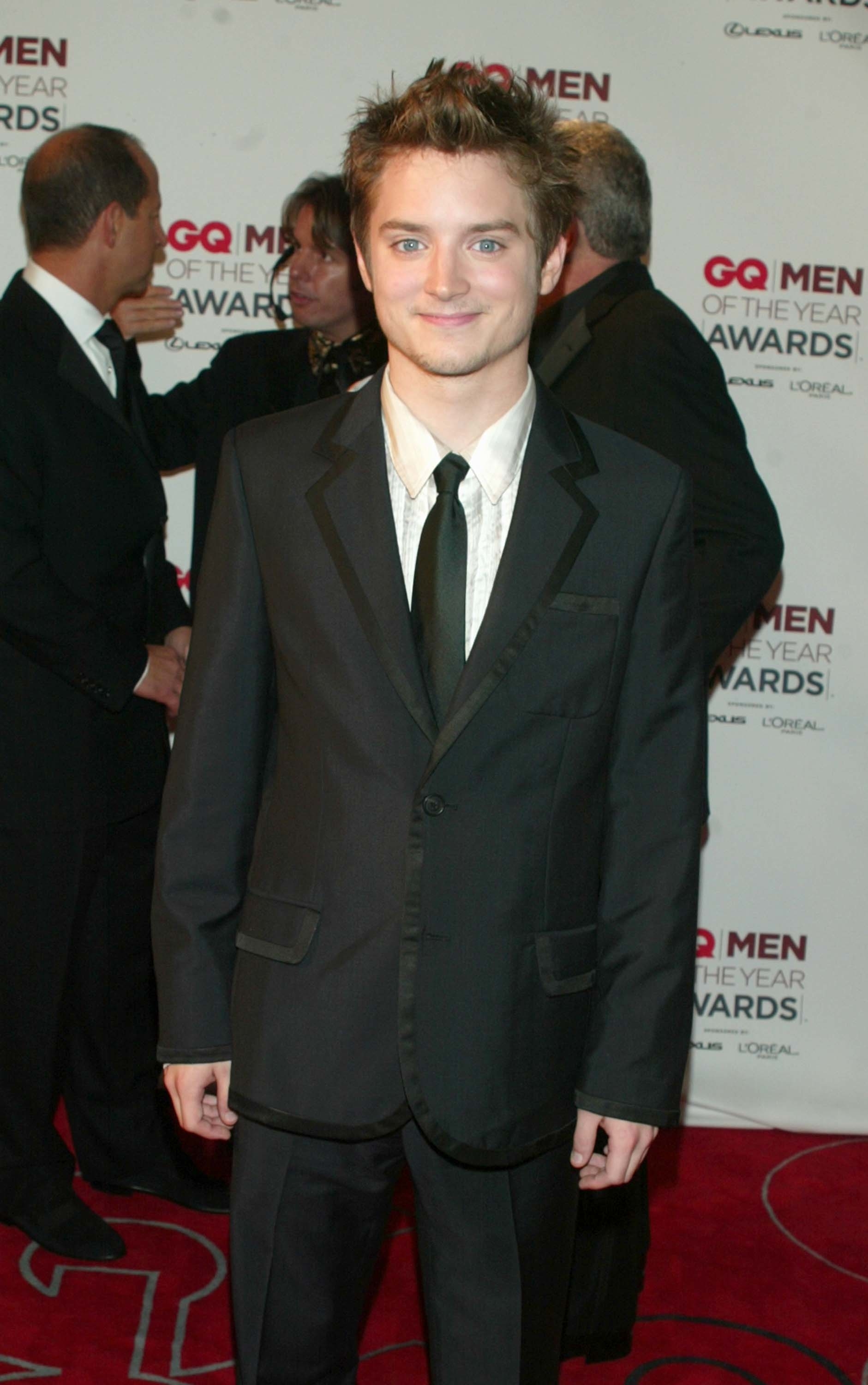 Smiling in a suit and tie on the red carpet