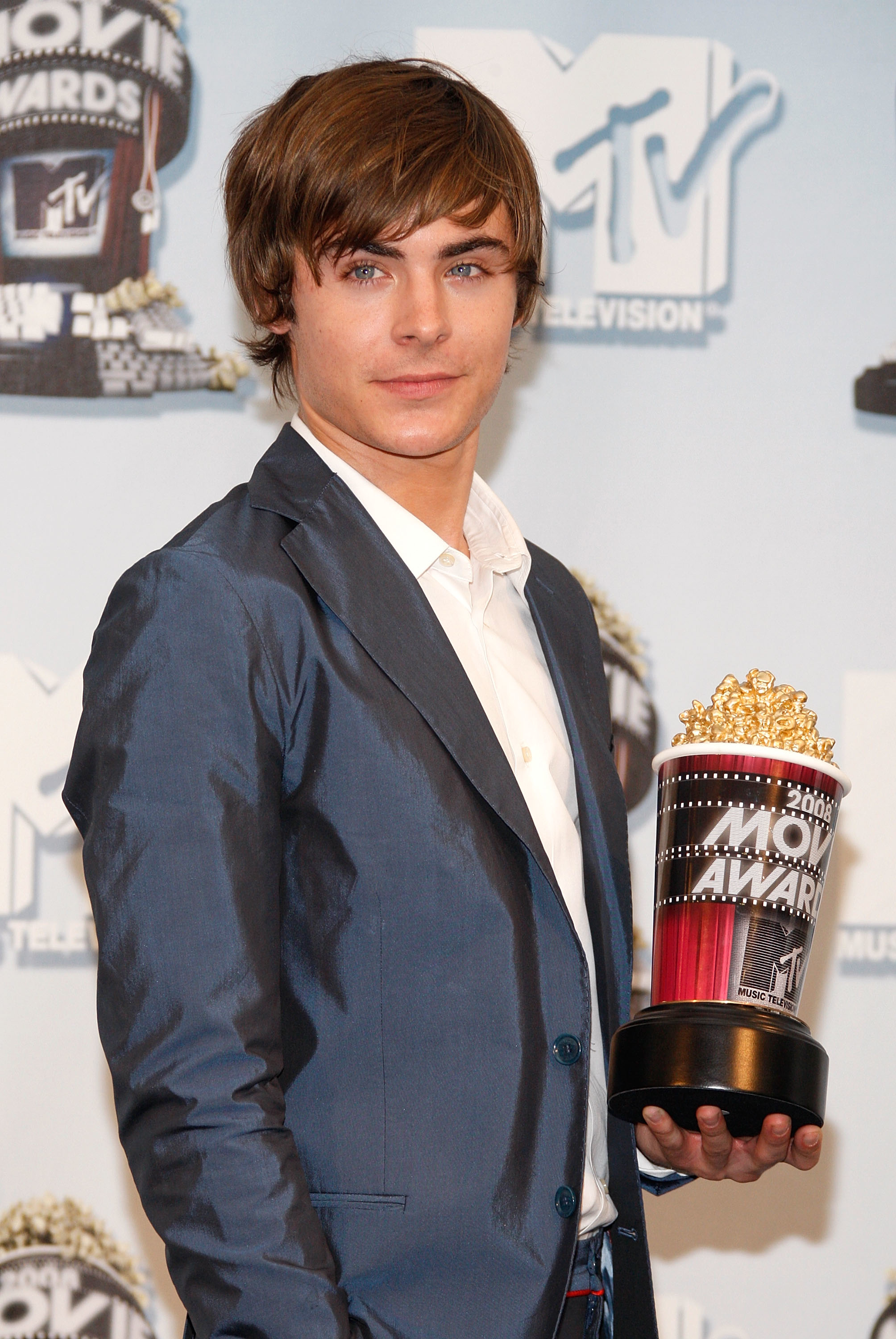In a suit and holding an MTV Movie Award