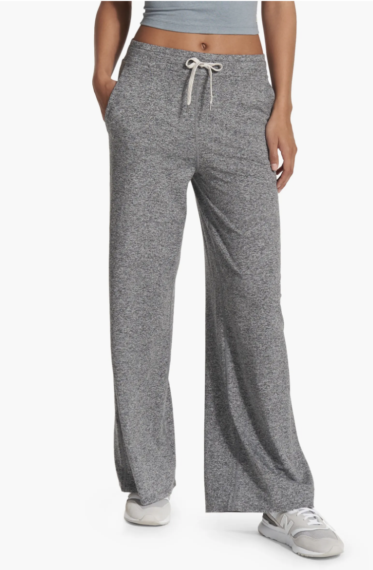 Gray sweatpants with drawstring waist on a model, paired with white sneakers. Suitable for casual wear