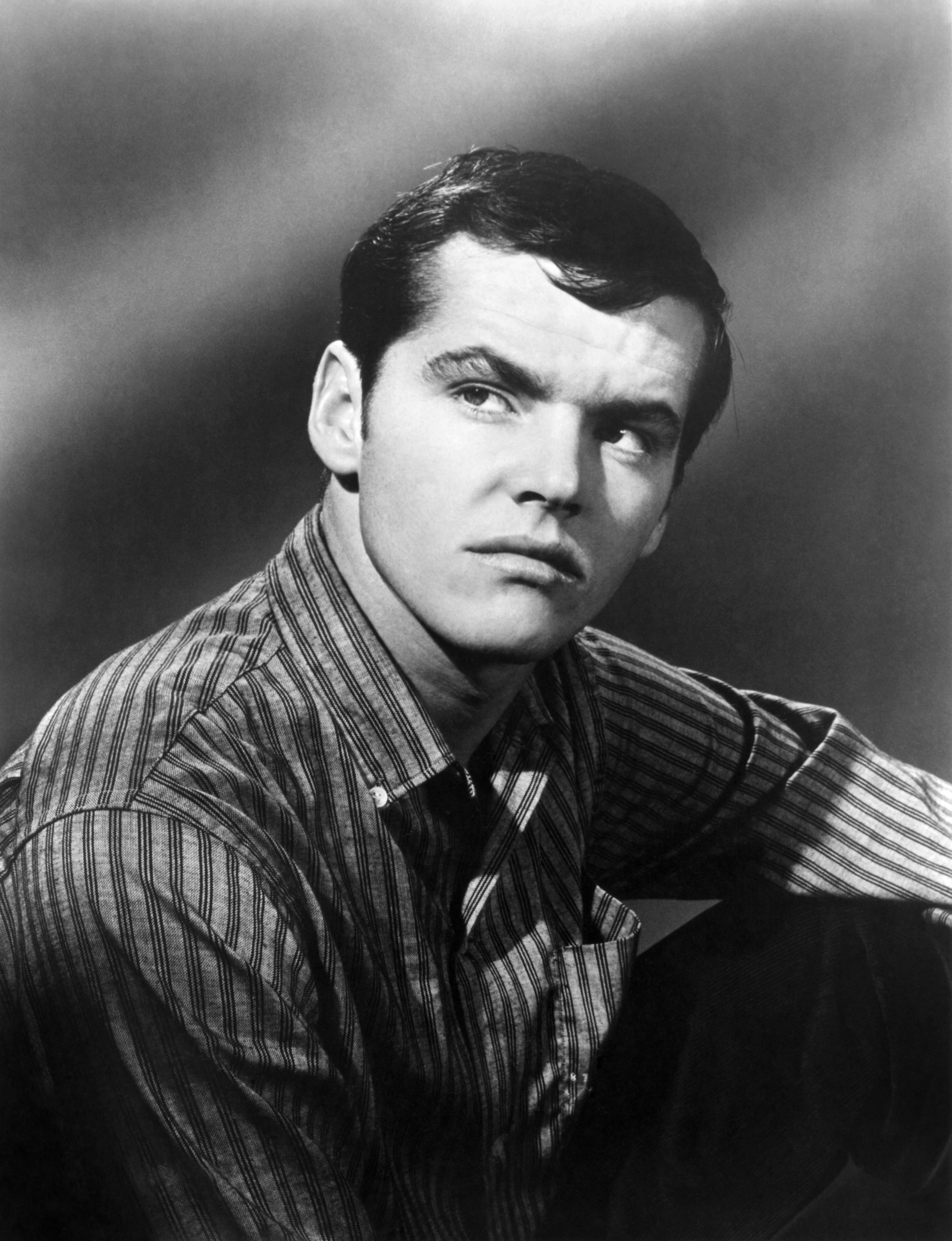 In a black-and-white headshot, wearing a striped shirt