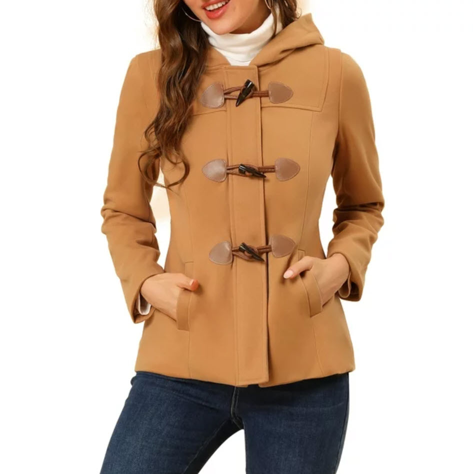 Person in a tan coat with toggle buttons and jeans