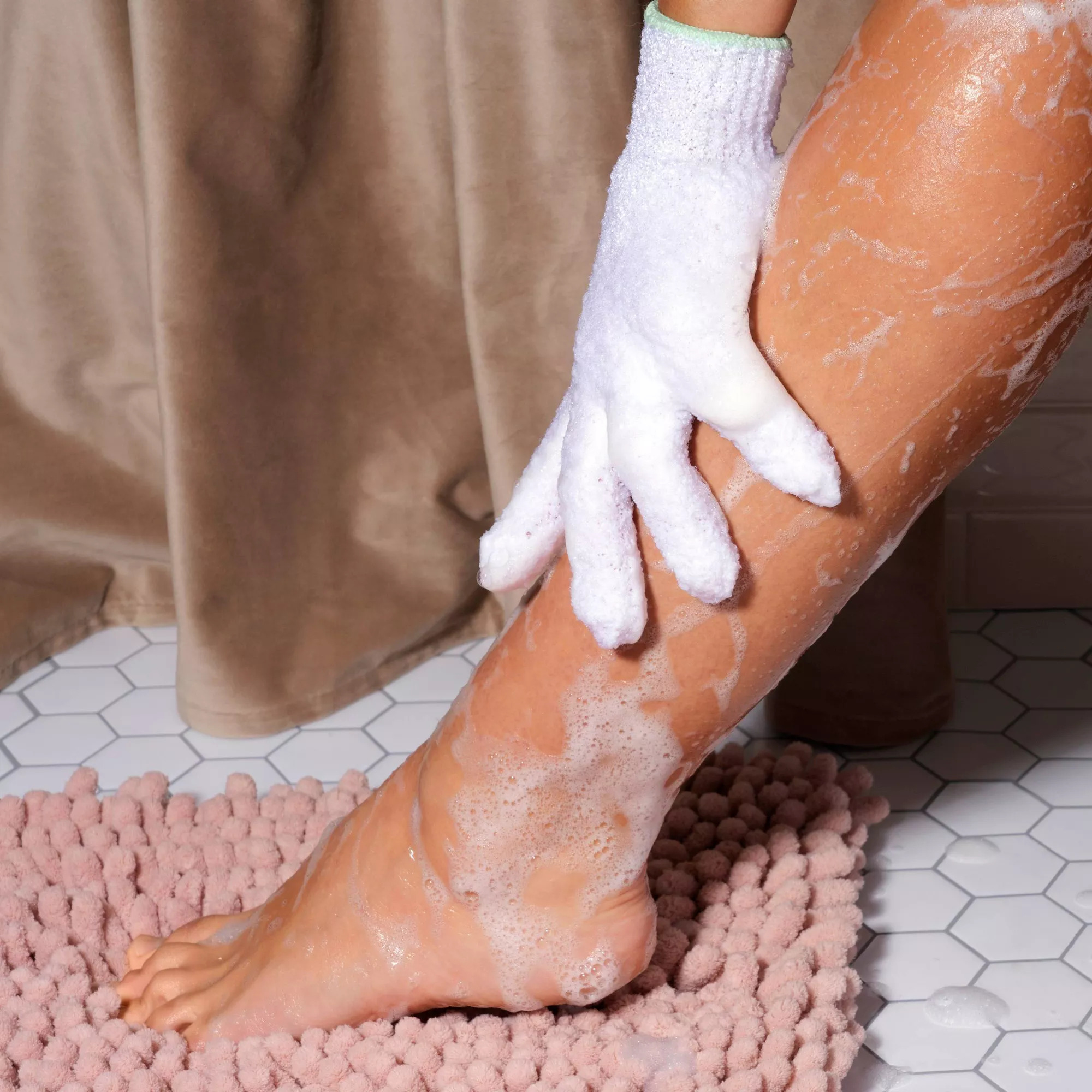 A model wearing the glove and scrubbing their leg