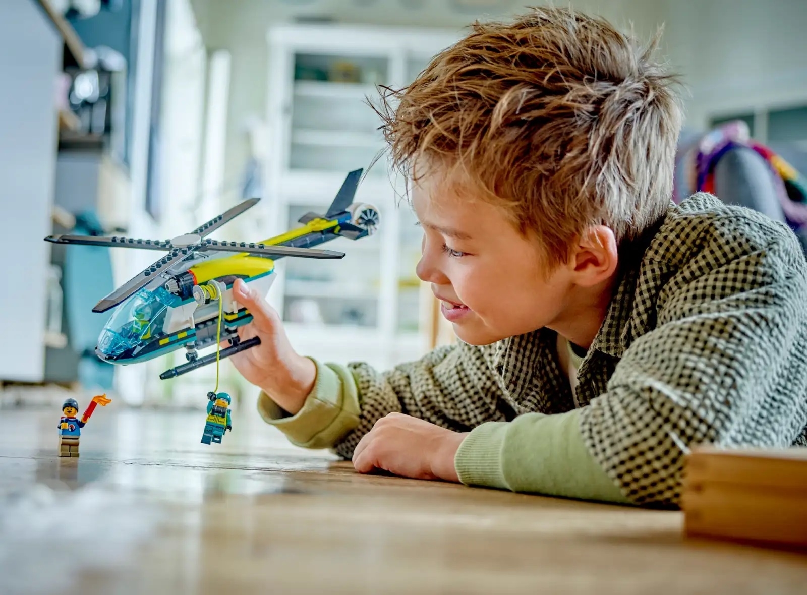 A young boy plays with a LEGO helicopter