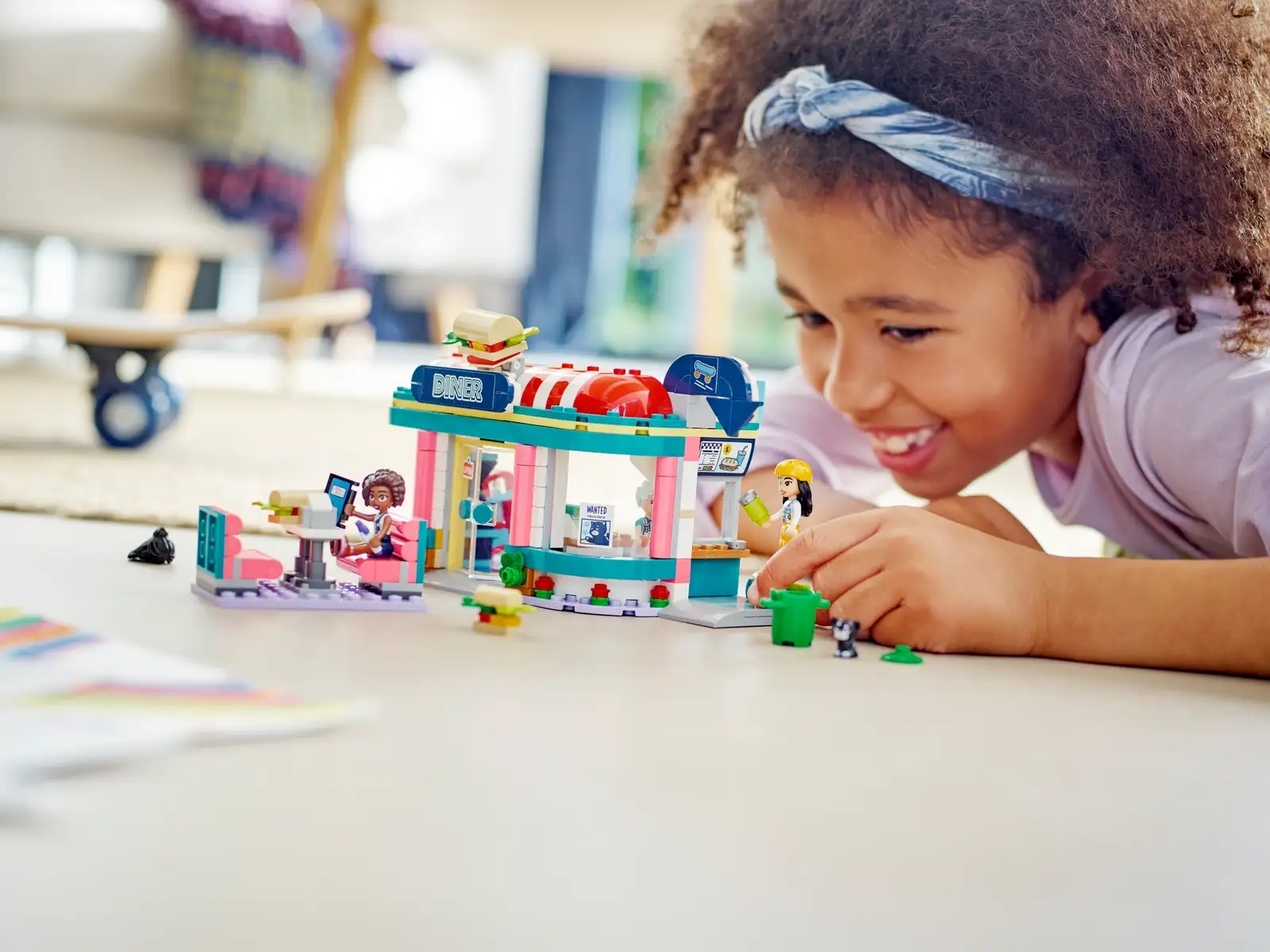 A young girl plays with a diner LEGO set