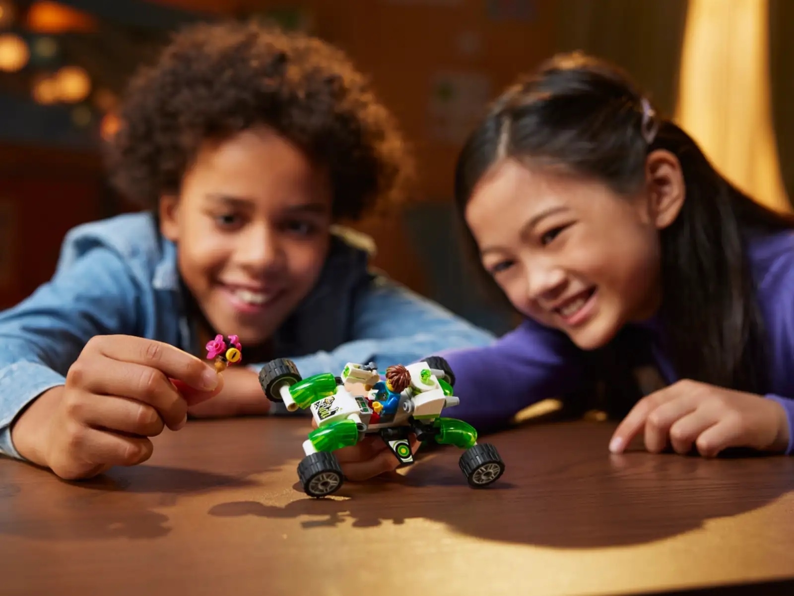 Two kids play with a LEGO vehicle
